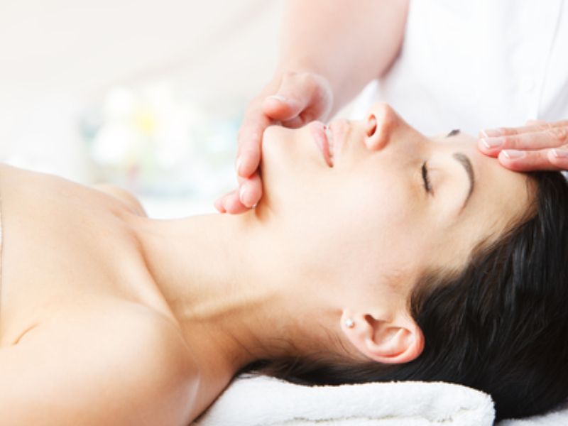 Sarah Butler Therapies offers Facials - image of lady with dark hair lying on her back receiving a facial